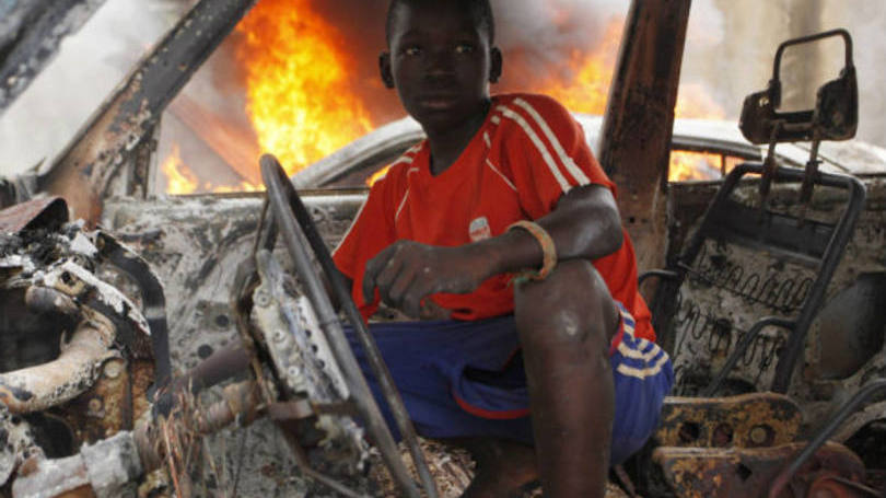 Na República Centro-Africana, menino brinca dentro de um carro destruído. Tropas francesas se deslocaram para o país africano para conter uma onda de violência entre cristãos e muçulmanos.