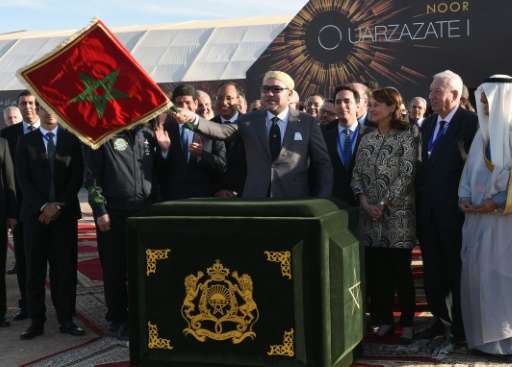 Rei marroquino Mohammed VI (C) as ondas a bandeira marroquina, enquanto inaugura a planta Noor 1 Concentrated Solar Power