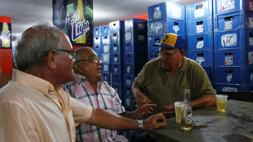 Venezuelanos tomando cerveja Polar em um bar de Maracaibo