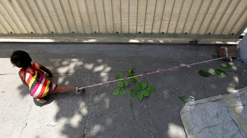 Índia Criança presa em uma pedra é fotografada nas ruas de Ahmedabad, na Índia. Seus pais estavam trabalhando em um campo de obras próximo do local para ganhar cerca de 4 dólares por dia e não tinham com quem deixa-la. De acordo com a Reuters, há hoje na Índia 40 milhões de operários nessa situação e um em cada cinco é mulher.