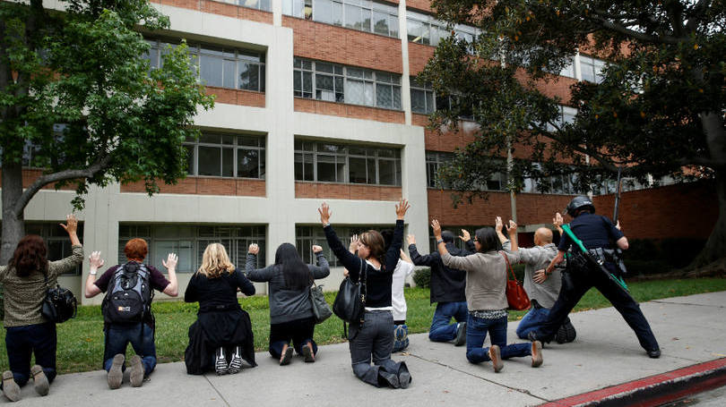 Estados Unidos  Policial revista um grupo de alunos da UCLA, universidade que fica na Califórnia, depois de o campus ter sido fechado por conta da presença de um atirador. Segundo informações das autoridades locais, esse atirador era o ex-aluno Mainak Sarkar, 38 anos, e tinha uma lista de pessoas que ele queria executar, um professor entre eles.  Depois de matar o professor, Sarkar se suicidou. A polícia ainda encontrou em sua residência, no Minessota, uma mulher morta com um tiro.