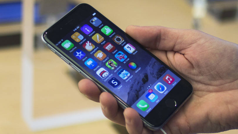 Consumidor segura um iPhone 6: em casos raros, os carregadores de dois pinos podem quebrar e criar risco de choque elétrico quando tocados